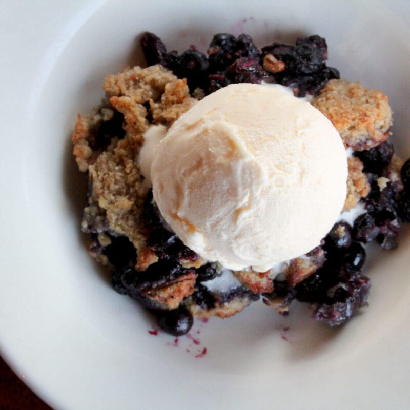 Ice cream over blueberry crumble